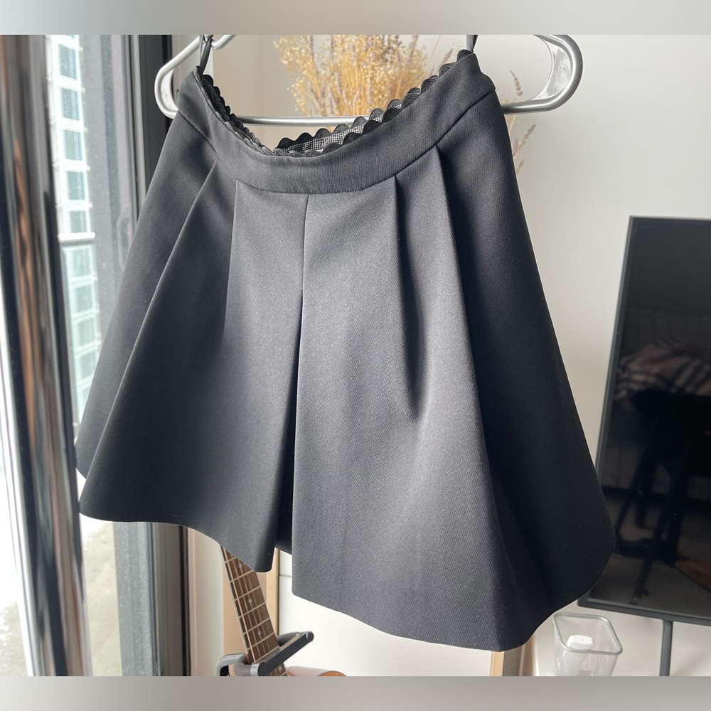 Black pleated drop-hem mini skirt